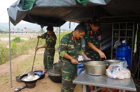 -Đồng chí Lữ đoàn trưởng kiểm tra chế biến món ăn tại khu vực tập kết trước chiến đấu.