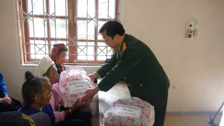 Đại tá Trương Minh Đức - Phó Chính ủy Bộ CHQS tỉnh tặng quà cho các gia đình khó khăn tại xã Phiêng Pằn.