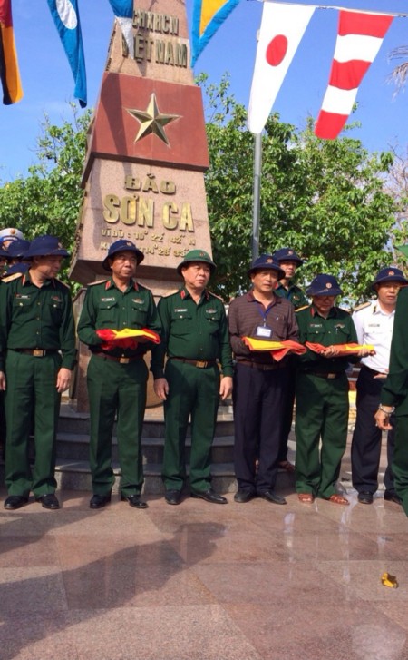 Thiếu tướng Hoàng Hữu Thế (thứ hai, trái sang) trân trọng nhận lá cờ Tổ quốc  do cán bộ, chiến sĩ đảo Sơn Ca tặng Bảo tàng Quân khu.