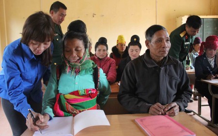 Cán bộ và tri thức trẻ tình nguyện giúp nông dân xã Mường Và học chữ.
