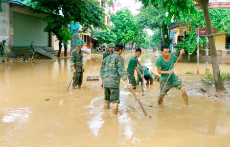 Chiến sĩ Sư đoàn tham gia khơi thông bùn đất trên các tuyến phố tại phường Hồng Hà, thành phố Yên Bái.