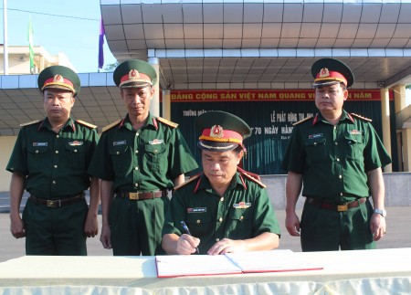 Đại tá Nguyễn Công Bính, Chính ủy Trường Quân sự Quân khu ký xác nhận giao ước thi đua của các cơ quan, khoa giáo viên và đơn vị. Ảnh: PHẠM TÙNG