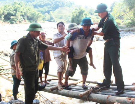 Bộ đội và dân quân Bộ CHQS tỉnh Lào Cai đưa người dân bị thương đi cấp cứu sau trận lũ.