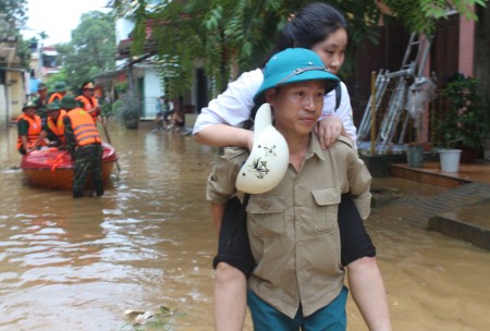 Dân quân phường Hồng Hà, thành phố Yên Bái, tỉnh Yên Bái giúp các cháu học sinh vượt mưa lũ đến trường.
