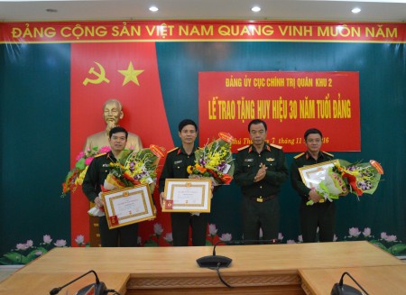 Chủ nhiệm chính trị Quân khu trao Huy hiệu 30 năm tuổi Đảng và tặng hoa chúc mừng các đảng viên.