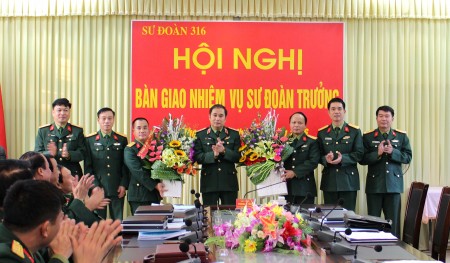  Thiếu tướng Phùng Sĩ Tấn tặng hoa chúc mừng hai đồng chí.