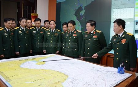 Bộ trưởng Ngô Xuân Lịch nghe kíp trực SSCĐ tại Sở chỉ huy K2000 báo cáo tình hình.  