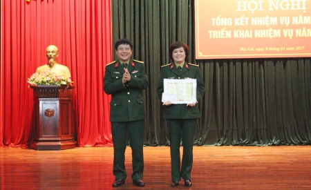 Đại tá Nguyễn Như Bách tặng Bằng khen của Chính ủy Quân khu cho hội viên Hội phụ nữ Đoàn Văn công Quân khu.