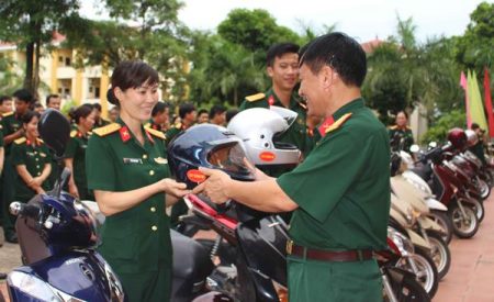 Đại tá Trần Ngọc Tuấn, Phó Chủ nhiệm Chính trị Quân khu trao mũ bảo hiểm đã dán tem phiên hiệu đơn vị cho quân nhân trong cơ quan.